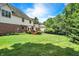 Expansive backyard featuring lush lawn, mature trees, and a view of the home's exterior at 8819 Anchor Bay Ct, Indianapolis, IN 46236
