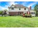 Spacious lawn with partial view of home with brick accents, deck, and established garden at 8819 Anchor Bay Ct, Indianapolis, IN 46236