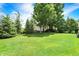 Spacious backyard with lush green lawn, mature trees, and white garden shed at 8819 Anchor Bay Ct, Indianapolis, IN 46236