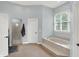 Bright bathroom featuring a tub with marble surround, separate shower, and natural light from a window at 8819 Anchor Bay Ct, Indianapolis, IN 46236