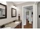 Bathroom with granite sink and double mirrors leading into bedroom area with natural lighting at 8819 Anchor Bay Ct, Indianapolis, IN 46236
