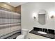 Bathroom features shower with curtain, vanity sink with black countertop, and modern fixtures at 8819 Anchor Bay Ct, Indianapolis, IN 46236