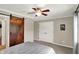Comfortable bedroom with rustic sliding door access and view to organized living space at 8819 Anchor Bay Ct, Indianapolis, IN 46236