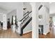 Bright foyer featuring staircase with dark wood railing, wood floors and large column at 8819 Anchor Bay Ct, Indianapolis, IN 46236