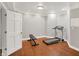Home gym with weight bench, treadmill, wood flooring, and recessed lighting at 8819 Anchor Bay Ct, Indianapolis, IN 46236
