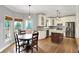 Open kitchen and dining area with stainless steel appliances, granite countertops, white cabinets, and hardwood floors at 8819 Anchor Bay Ct, Indianapolis, IN 46236
