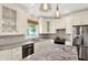 Modern kitchen featuring stainless steel appliances, granite countertops, white cabinets, and decorative pendant lights at 8819 Anchor Bay Ct, Indianapolis, IN 46236