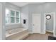 Bright main bathroom with tile floors and a luxurious sunken tub under a large window at 8819 Anchor Bay Ct, Indianapolis, IN 46236