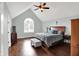 Comfortable main bedroom with vaulted ceiling, ceiling fan, hardwood floors, and arched window at 8819 Anchor Bay Ct, Indianapolis, IN 46236
