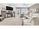 Cozy living room features stone fireplace, plush seating, neutral carpet, and a lake view at 102 Clarendon Dr # 409, Noblesville, IN 46062