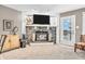 Cozy living room with stone fireplace, television, and sliding door access to the outdoor area at 102 Clarendon Dr # 409, Noblesville, IN 46062