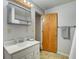 Bright bathroom features a single sink vanity, medicine cabinet, and a wood door at 1433 E Fletcher Ave, Indianapolis, IN 46203