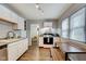 Updated kitchen showcasing white cabinets, modern appliances, and a dining area with natural light at 1433 E Fletcher Ave, Indianapolis, IN 46203