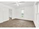 Well-lit bedroom with neutral carpet, white walls, a ceiling fan, and natural light at 1901 N Tillotson Ave, Muncie, IN 47304