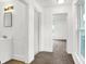 Bright hallway featuring white walls, trim, and neutral carpet leading to a bedroom at 1901 N Tillotson Ave, Muncie, IN 47304