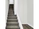 Carpeted staircase with white walls and wood-look floors at 1901 N Tillotson Ave, Muncie, IN 47304