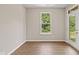 Inviting living room with wood-look floors, bright window, and a glass-paned door at 2184 Galleone Way, Plainfield, IN 46168