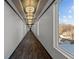 Long hallway features unique light fixtures and an exterior window with a view of neighboring homes at 1155 S Rangeline Rd # 504, Carmel, IN 46032