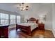 Spacious main bedroom with hardwood floors, ceiling fan, and large bed at 12106 Cabri Ln, Fishers, IN 46037