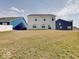 Large backyard with green grass, a view of the back of the house, and a blue house in the back at 2898 Creekridge Ct, Columbus, IN 47201