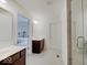 Bathroom featuring dual vanities, a glass-enclosed shower with tiled walls and a doorway leading to a bedroom at 2898 Creekridge Ct, Columbus, IN 47201