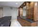 Modern basement bar featuring granite countertops, custom wood cabinets, and glass shelving at 4499 W 131St St, Carmel, IN 46074