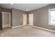A carpeted room with gray walls, white trim, two doors, and a window at 4499 W 131St St, Carmel, IN 46074