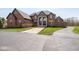 Stately brick home featuring a circular driveway and lush green lawn at 4499 W 131St St, Carmel, IN 46074