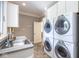 Efficient laundry room showcasing stacked washer and dryer units, sink, and storage at 4499 W 131St St, Carmel, IN 46074