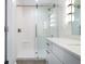Well-lit bathroom with glass shower, white vanity and gray-tone tile flooring at 806 7Th St, Columbus, IN 47201