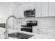 Close-up of the kitchen featuring a stainless steel microwave, oven, and white countertops at 806 7Th St, Columbus, IN 47201