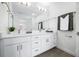 Bright bathroom featuring double sinks, white cabinets, modern fixtures and a large mirror at 822 7Th St, Columbus, IN 47201