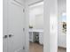 Clean powder room with neutral-toned tiling, white vanity, and a view to the exterior at 822 7Th St, Columbus, IN 47201