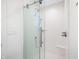Bright shower featuring a glass enclosure, white tiled walls, and modern fixtures at 822 7Th St, Columbus, IN 47201