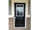 A front door with glass pane, brick facade, secure lockbox, and Ring doorbell for added security and convenience at 696 Scarsdale Ln, Danville, IN 46122
