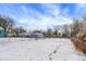 The backyard is snow-covered with a chain-link fence, bare trees, and a storage shed with a blue sky background at 5845 Rawles Ave, Indianapolis, IN 46219