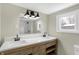 Beautiful bathroom featuring double sinks, modern fixtures, wood cabinets and a large mirror with lots of light at 5845 Rawles Ave, Indianapolis, IN 46219