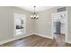 Dining room with wood floors and a view into a modern white kitchen at 5845 Rawles Ave, Indianapolis, IN 46219