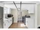 Modern kitchen with white cabinets and stainless steel appliances, including washer and dryer at 5845 Rawles Ave, Indianapolis, IN 46219