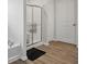 Modern bathroom with shower, tub, and wood-look floors at 211 Walker Dr, Whiteland, IN 46184