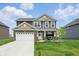 Charming two-story home featuring a well-manicured lawn and attached two-car garage at 211 Walker Dr, Whiteland, IN 46184