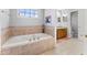 Relaxing bathroom with soaking tub, double vanity, and tile floors at 6093 Boulder Ct, Columbus, IN 47201