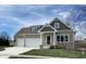 Two-story craftsman style home with attached two-car garage, stone accents, and a welcoming front porch at 5286 Stonehaven Ln, Columbus, IN 47201