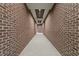 Long hallway with symmetrical red brick walls and modern recessed lighting at 1155 S Rangeline Rd # 507, Carmel, IN 46032