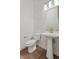 Stylish powder room with tiled accent wall, pedestal sink, and modern lighting fixtures at 1155 S Rangeline Rd # 507, Carmel, IN 46032