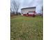 View of the spacious backyard with a red deck featuring chairs and an umbrella at 6951 Governors Point Blvd, Indianapolis, IN 46217