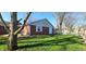 Wide shot of the backyard showing the garage, home, and a lush green lawn at 3230 Meadowcrest Dr, Anderson, IN 46011