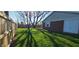 Backyard shot of the detached garage with white doors and a partially fenced in yard at 3230 Meadowcrest Dr, Anderson, IN 46011