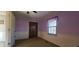 Bright bedroom featuring purple walls, wainscoting, closet, and a window for natural light at 3230 Meadowcrest Dr, Anderson, IN 46011