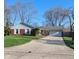 Charming brick home with a well-maintained lawn and long driveway leading to an attached garage at 3230 Meadowcrest Dr, Anderson, IN 46011
